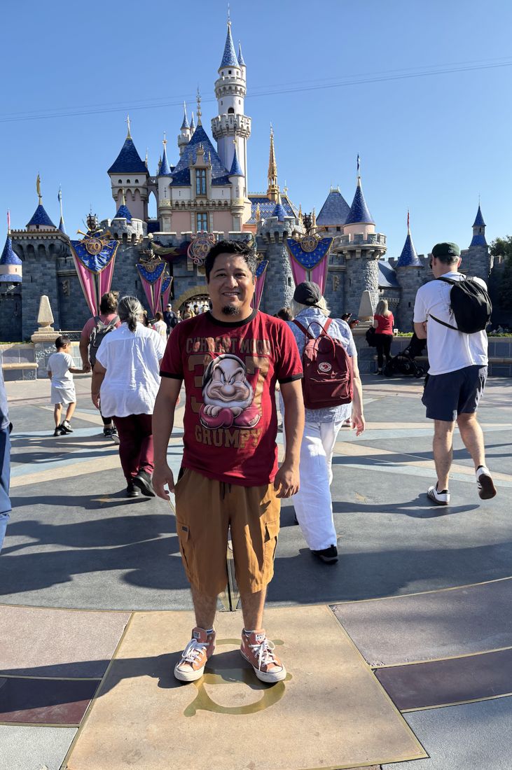 Lenin Martínez frente al castillo en Disneyland